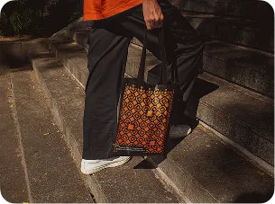 Pessoa carregando uma ecobag estampada ao descer uma escadaria